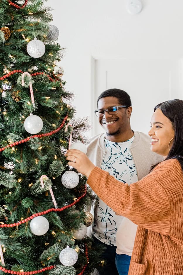 couple decorating a christmas tree