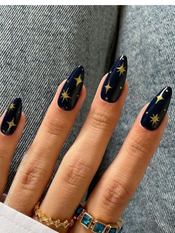 These deep navy nails are adorned with delicate gold stars, giving them a celestial and magical vibe. 