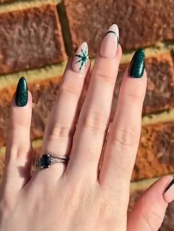 deep emerald green glitter polish on most of these nails, with a minimalist green starburst accent on others