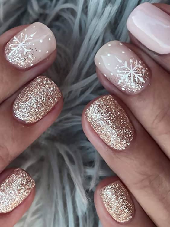 These short nails feature a beautiful mix of rose gold glitter and delicate white snowflake patterns. 