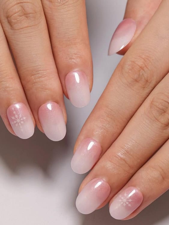 This soft pink-to-white ombré design is a subtle, romantic choice. 

The delicate snowflakes on a couple of the nails add a hint of seasonal flair without being too bold.