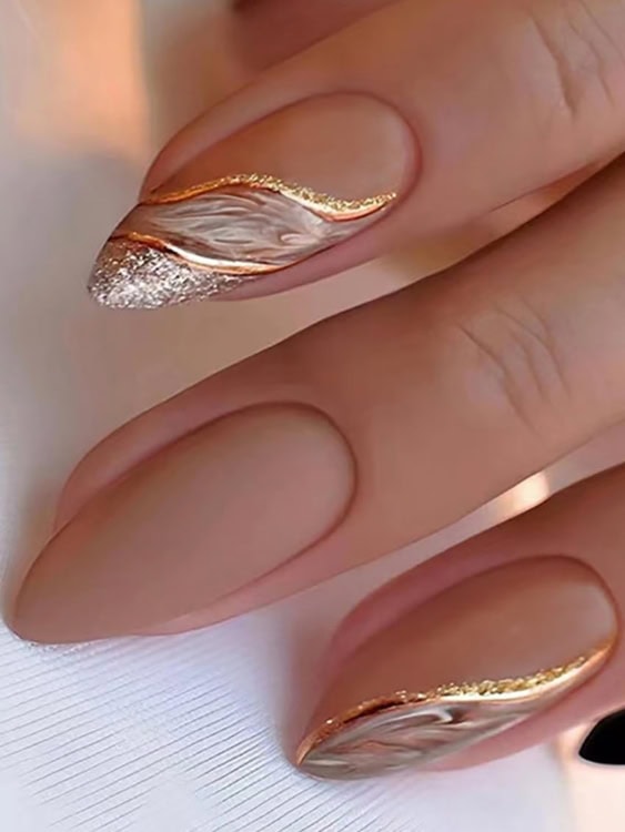 combination of a matte nude base with a shimmering gold wave nails 