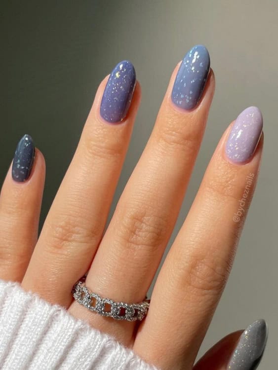 These nails feature a soft ombre effect, transitioning from dark blue to light lavender. 