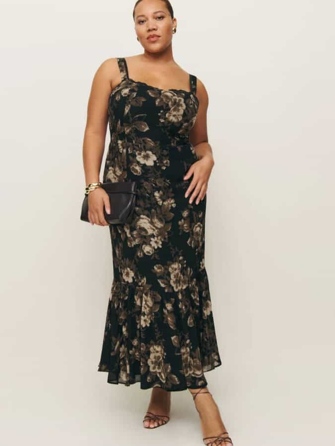 curvy women in a fit and flare dress in black and gold floral pattern