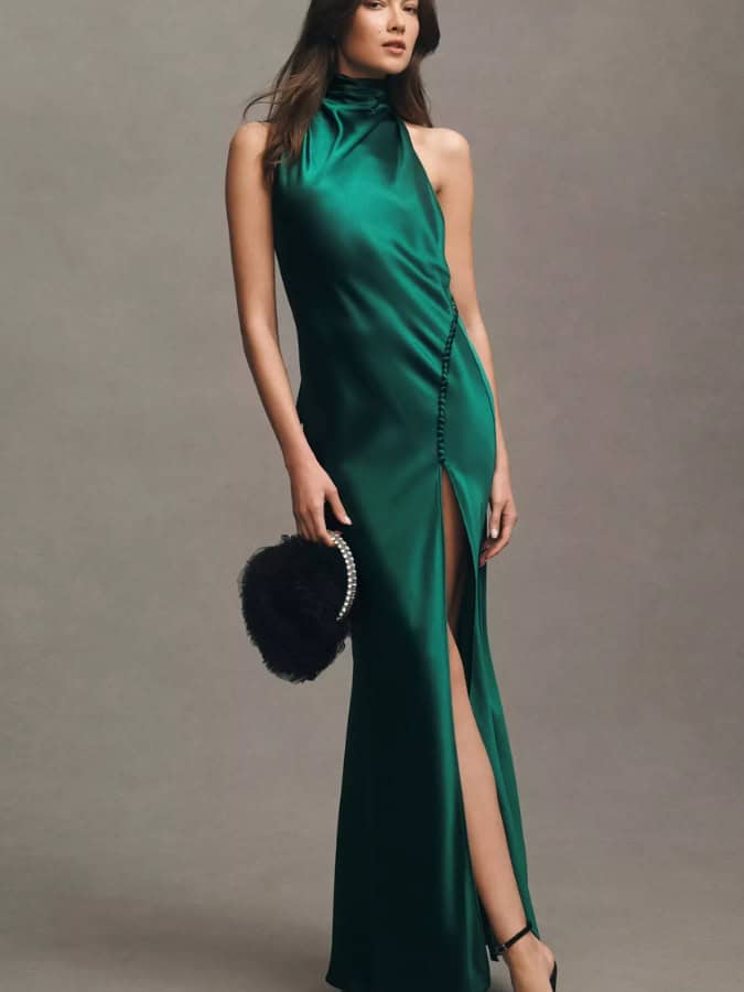 women in stain dark green high neck dress with a high split and button detail along split