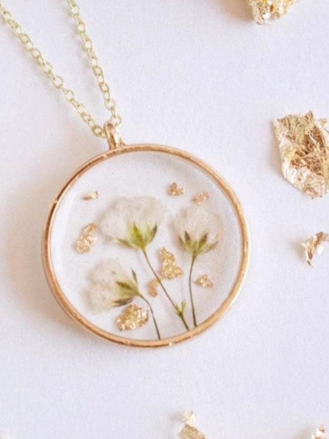 a gold ring neclace with resin flowers inside