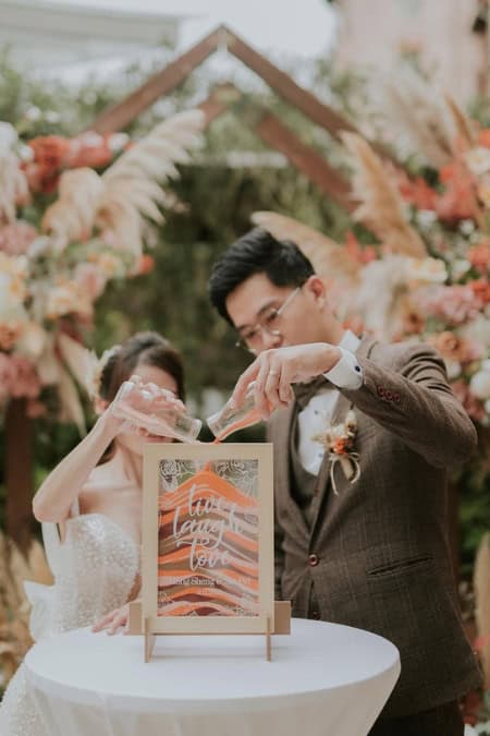 couple filling up their sand jar at sand unity wedding ceremony